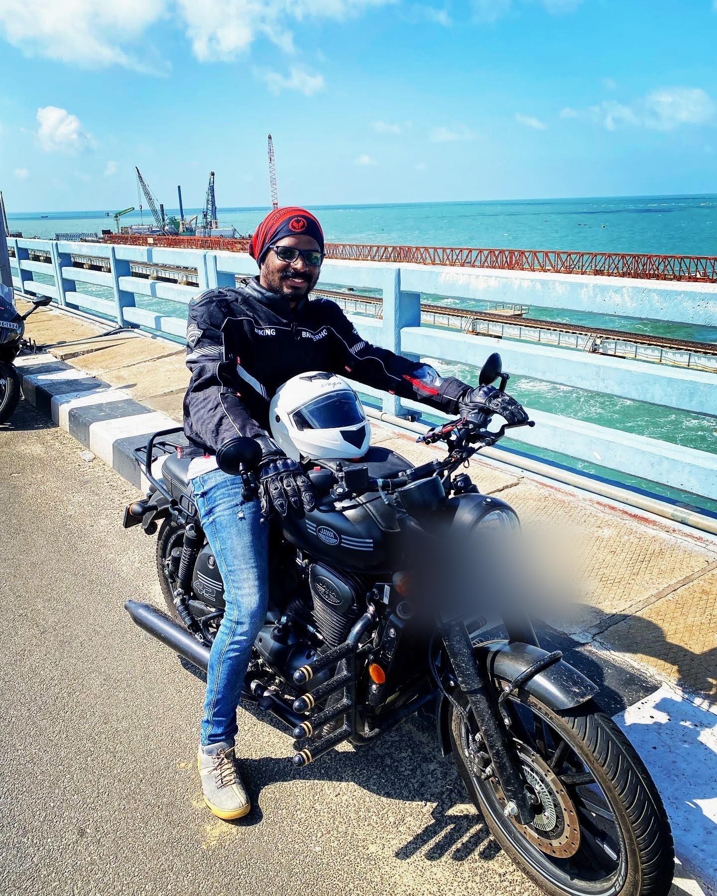 Vairav on a motorcycle on the Pamban Bridge in Rameswaram, the sea visible on both sides.